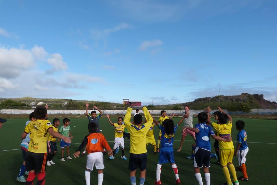 A volunteer sports coach in Ecuador leads children through a warm up A warm up session as part of Projects Abroad's volunteer sports coaching in Ecuador